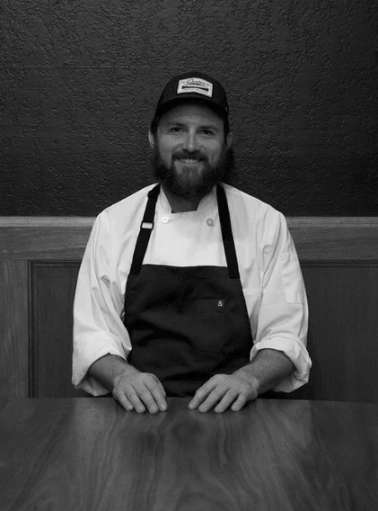 Chef and owner Andy Kroeger seated at a table at Fairchild