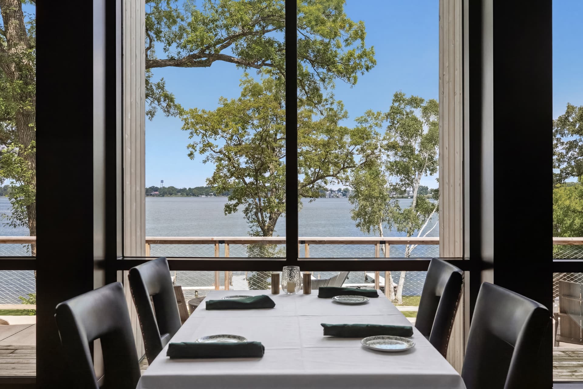 Set table framed by windows overlooking the water